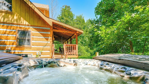 Een houten vakantiehuis met een hottub en een overdekt terras.