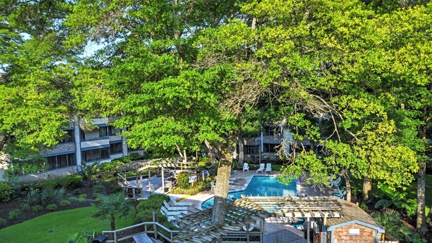 A resort with a swimming pool, outdoor seating, and lush greenery. - 1 Mi to Coast: Myrtle Beach Condo w/ Balconies! (Myrtle Beach)