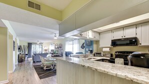 A modern kitchen with a large island, built-in appliances, and a dining area with a view. - 1 Mi to Coast: Myrtle Beach Condo w/ Balconies! (Myrtle Beach)