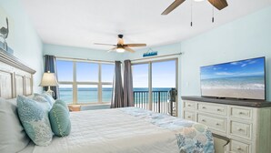 A bedroom with a bed, a TV, a ceiling fan, and a view of the ocean. - ETW 3006: Beach Paradise - Rise and shine on beach time! Book now! (Fort Walton Beach)
