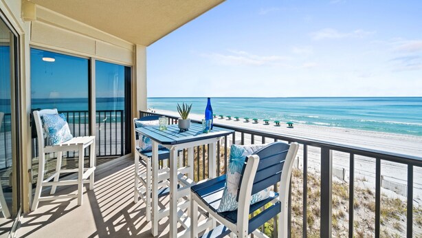 A balcony with a view of the beach, featuring a table, chairs, and a potted plant. - ETW 3006: Beach Paradise - Rise and shine on beach time! Book now! (Fort Walton Beach)
