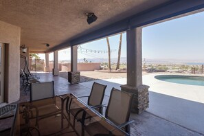 Patio esterno con piscina, zona relax e vista sul paesaggio.