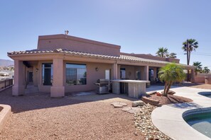 Une maison moderne dotée d’un patio, d’un barbecue extérieur et d’une piscine.