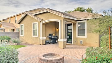 A residential house with a patio, a barbecue grill, and a fire pit.