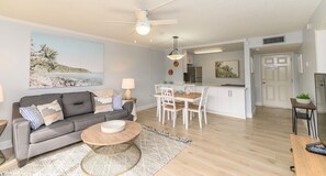 Un salon comprenant un canapé, une table basse et un coin repas avec des chaises et une table.