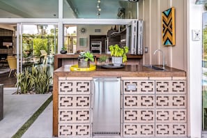 Eine moderne Küche mit integriertem Geschirrspüler, einer Holz Arbeitsplatte und einer dekorativen Spritzschutzwand.