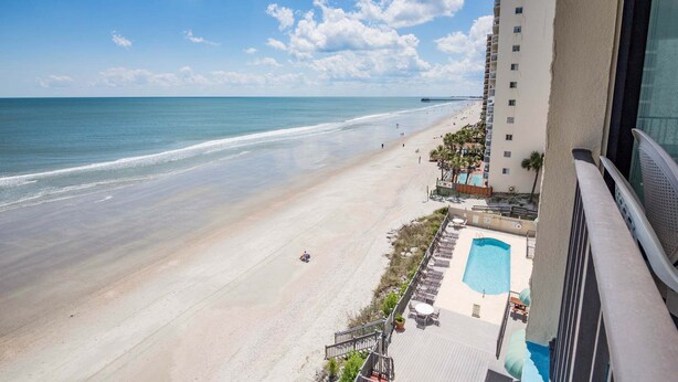A beach view from a balcony overlooking a swimming pool and a sandy beach. - *20% Off New Summer 2026 Bookings* (Garden City)