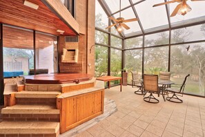 Un patio intérieur moderne doté d’un jacuzzi, d’un escalier en bois et d’un espace détente avec des chaises et une table.