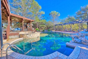 A swimming pool with a stone deck, wooden pergola, and outdoor seating area. - Amazing Ranch Sleeps 42 Plus! Located On 75 Acres With A Pool And Barn (Wimberley)