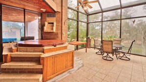 Een moderne binnentuin met een jacuzzi, houten trap en een zithoek met stoelen en een tafel.