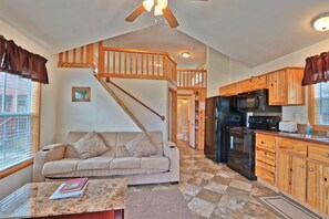A spacious living area with a sofa, coffee table, and a staircase leading to an upper level. - Amazing Ranch Sleeps 42 Plus! Located On 75 Acres With A Pool And Barn (Wimberley)