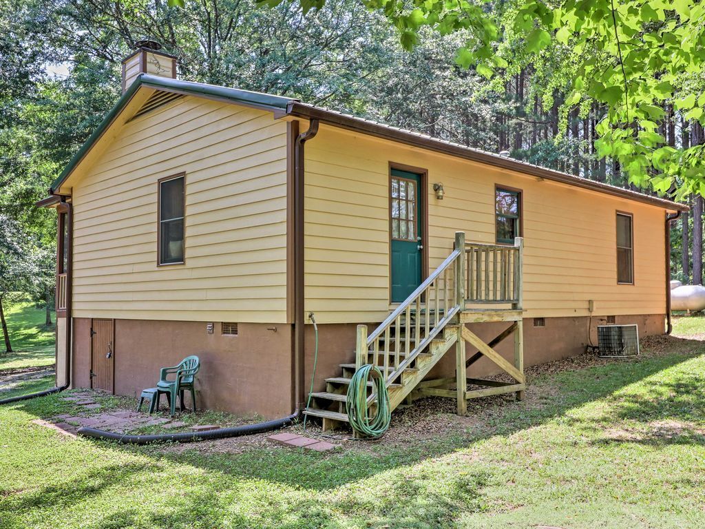 Une cabane de plain-pied avec un porche à l’avant et un petit escalier menant à une porte.