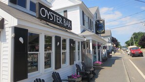 Un edificio bianco con un cartello che riporta "OYSTER BAR" e un cartello più piccolo per "THE PORT".