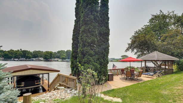 Une terrasse au bord du lac, dotée d’un espace barbecue couvert, de sièges d’extérieur et d’un belvédère.