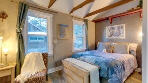 A bedroom with a bed, a chair, a bench, and a window. - Rustic Log Cabin w/ Studio ~ 5 Mi to Pikes Peak! (Green Mountain Falls)