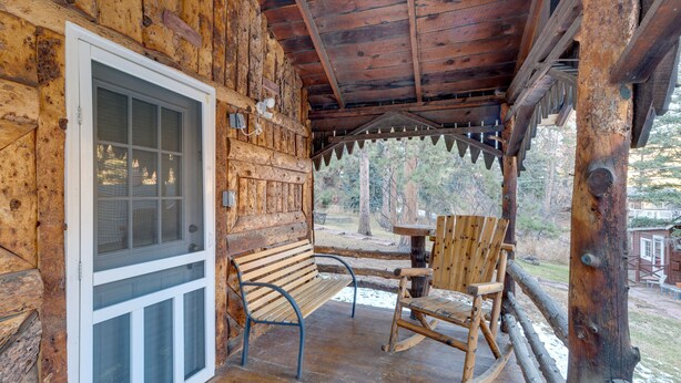 A wooden cabin with a porch, a bench, and a rocking chair. - Rustic Log Cabin w/ Studio ~ 5 Mi to Pikes Peak! (Green Mountain Falls)