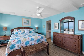 A bedroom with a bed, dresser, and a ceiling fan.