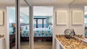 A bedroom with a bed, a nightstand, a mirror, and a view of the beach. - Mar Y Sol –Luxurious oceanfront  Key West Breathtaking Atlantic Sunrise Views (Key West)