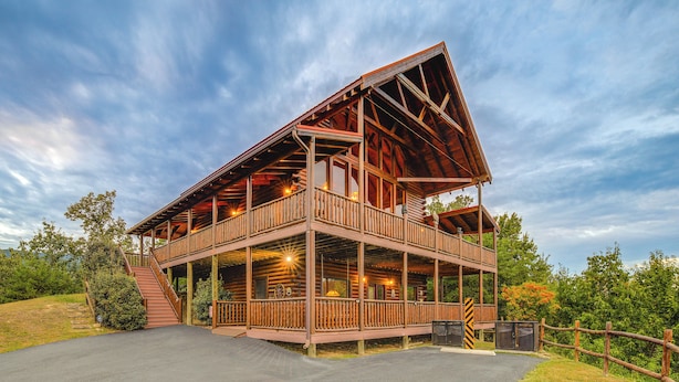 A two-story log cabin with a balcony, a covered porch, and a driveway. - Hot Tub + Games! Mtn-View Cabin Near Pigeon Forge (Sevierville)