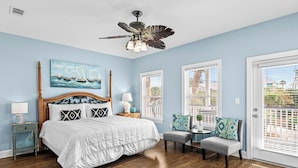 A bedroom with a bed, a nightstand, a chair, a ceiling fan, and a window with blinds. - Ocean Mist Cottage | Steps to Beach | Private Pool | Charming Neighborhood (Destin)