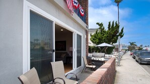 Un'area patio con posti a sedere all'aperto, un barbecue e vista sulla strada.