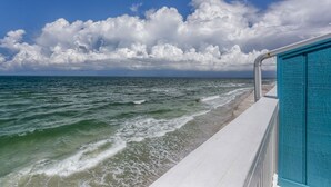 En strand med klar himmel och vågor som slår in mot land.