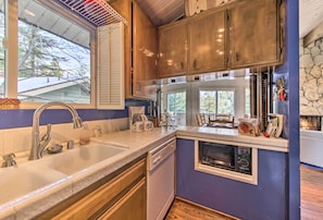 Enjoy cooking in this well-equipped kitchen with a large sink, dishwasher, and small oven.