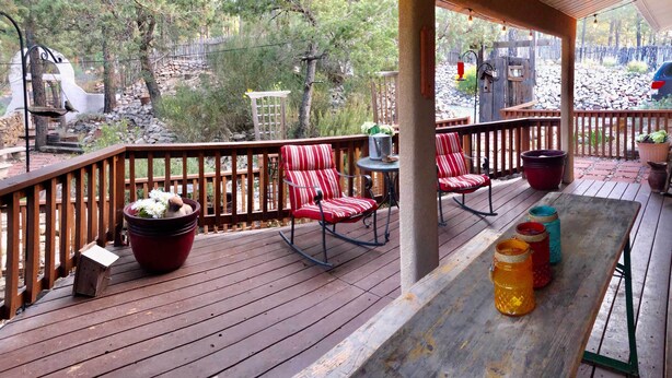 A wooden deck with rocking chairs and a table, surrounded by a wooden railing. - Quiet Ruidoso Hideaway - 2 Mi to Grindstone Lake! (Ruidoso)