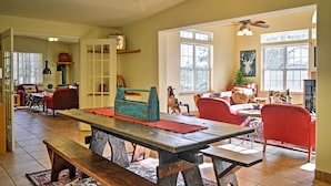 A spacious living room with a wooden dining table, red chairs, and a ceiling fan. - Quiet Ruidoso Hideaway - 2 Mi to Grindstone Lake! (Ruidoso)