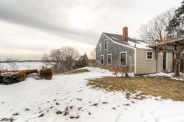 A house with a sloped roof, a chimney, and a small porch.