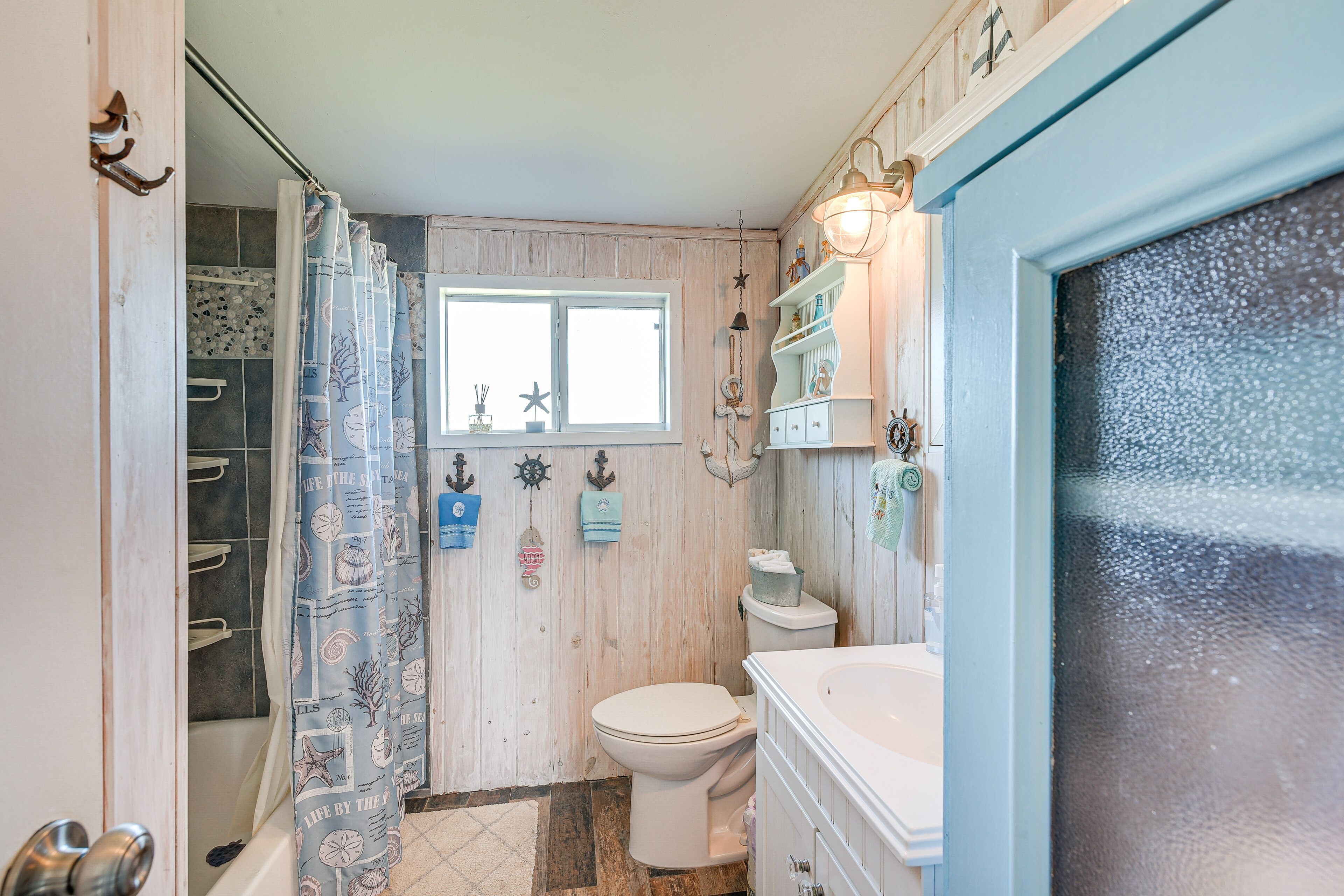 Ein Badezimmer mit Duschvorhang, Toilette und Waschtisch.