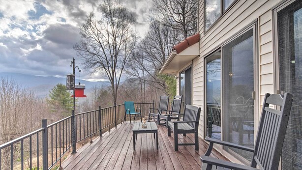 A wooden deck with outdoor furniture, a red lantern, and a view of trees and mountains. - Secluded Home w/ Views in Burnsville: Hike & Ski! (Burnsville)