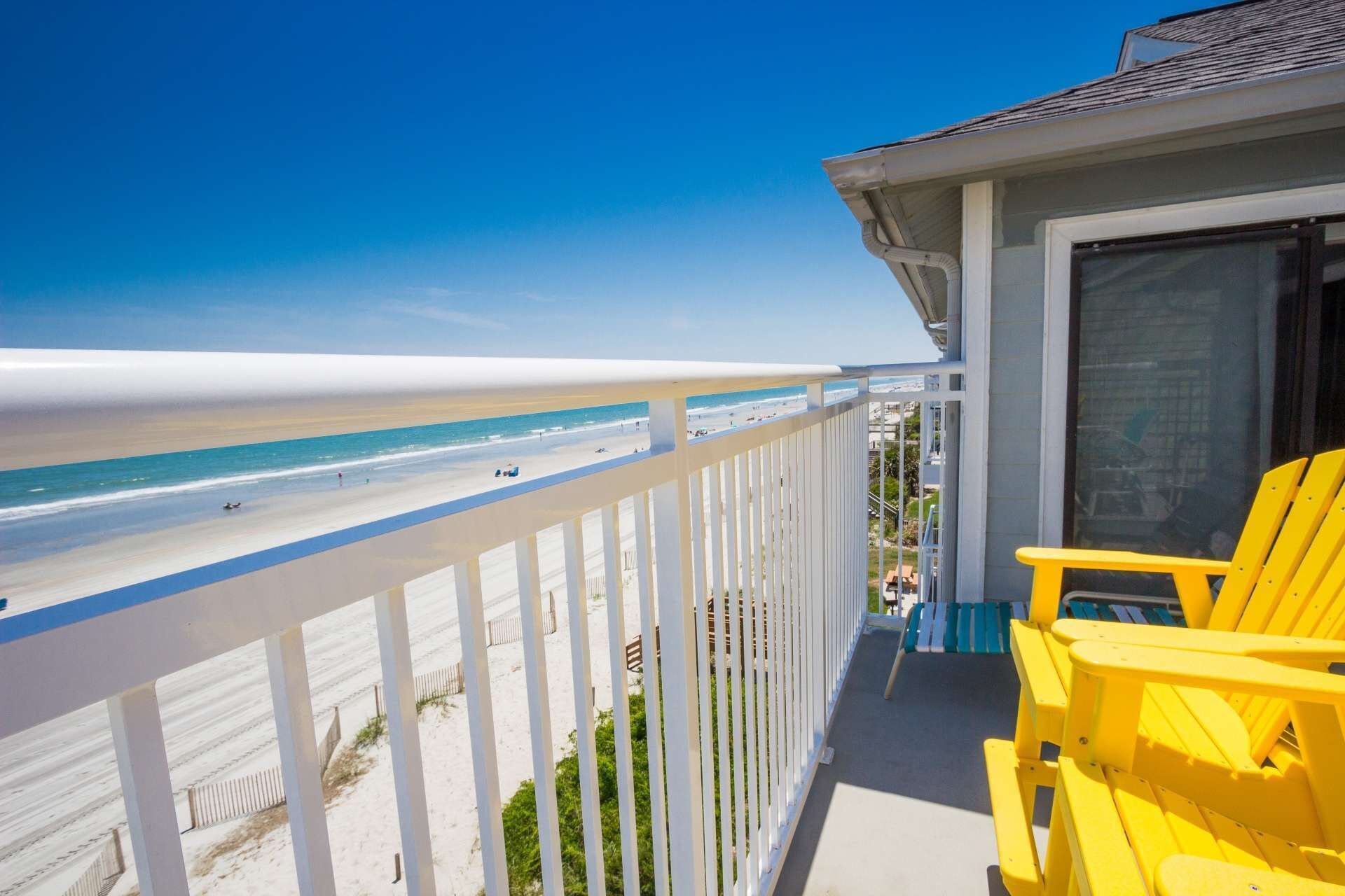 Un balcon avec vue sur la plage et l’océan.