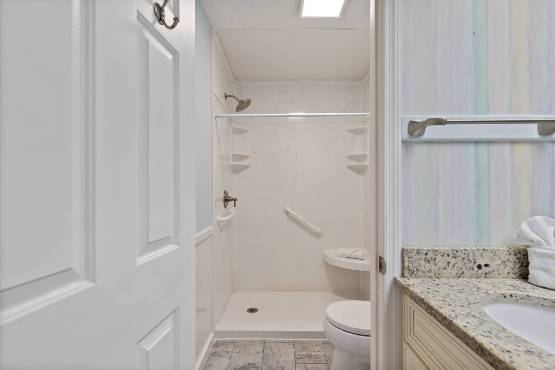 A bathroom with a shower, toilet, and sink.