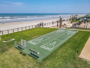A green shuffleboard court with a view of the beach and ocean. - 60 Steps to the Beach Deck (New Smyrna Beach)