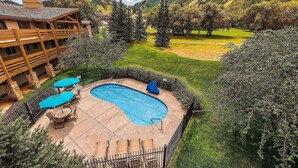Un espace piscine doté d’une terrasse en bois, d’une piscine et offrant une vue sur un paysage montagneux.