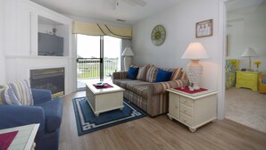 Una sala de estar con sofá, mesa de centro, televisor y chimenea.