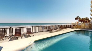 Une zone de baignade avec vue sur l’océan, un panneau indiquant la présence d’un sauveteur et un autre panneau indiquant l’absence de sauveteur.