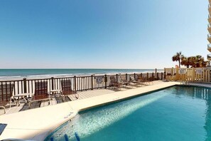 A pool area with a view of the beach, a lifeguard on duty sign, and a no lifeguard on duty sign. - *20% Off New Summer 2026 Bookings* (Garden City)