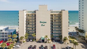 Un hôtel à plusieurs étages, nommé « Horizon Est », doté d’un parking et offrant une vue sur la plage.
