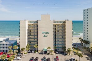 A multi-story hotel named 'Horizon East' with a parking lot in front, located near a beach. - *20% Off New Summer 2026 Bookings* (Garden City)