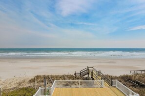 A beach with a wooden boardwalk leading to a staircase. - Lucky Enough – Pets Welcome, Ocean Views Included (Surf City)