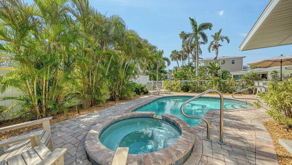 A pool area with two hot tubs and lounge chairs, surrounded by palm trees and a brick patio. - Heated Pool & Spa, FREE WiFi, Near AMI Beach & Village, Dog* (See Note) Friendly! (Anna Maria)