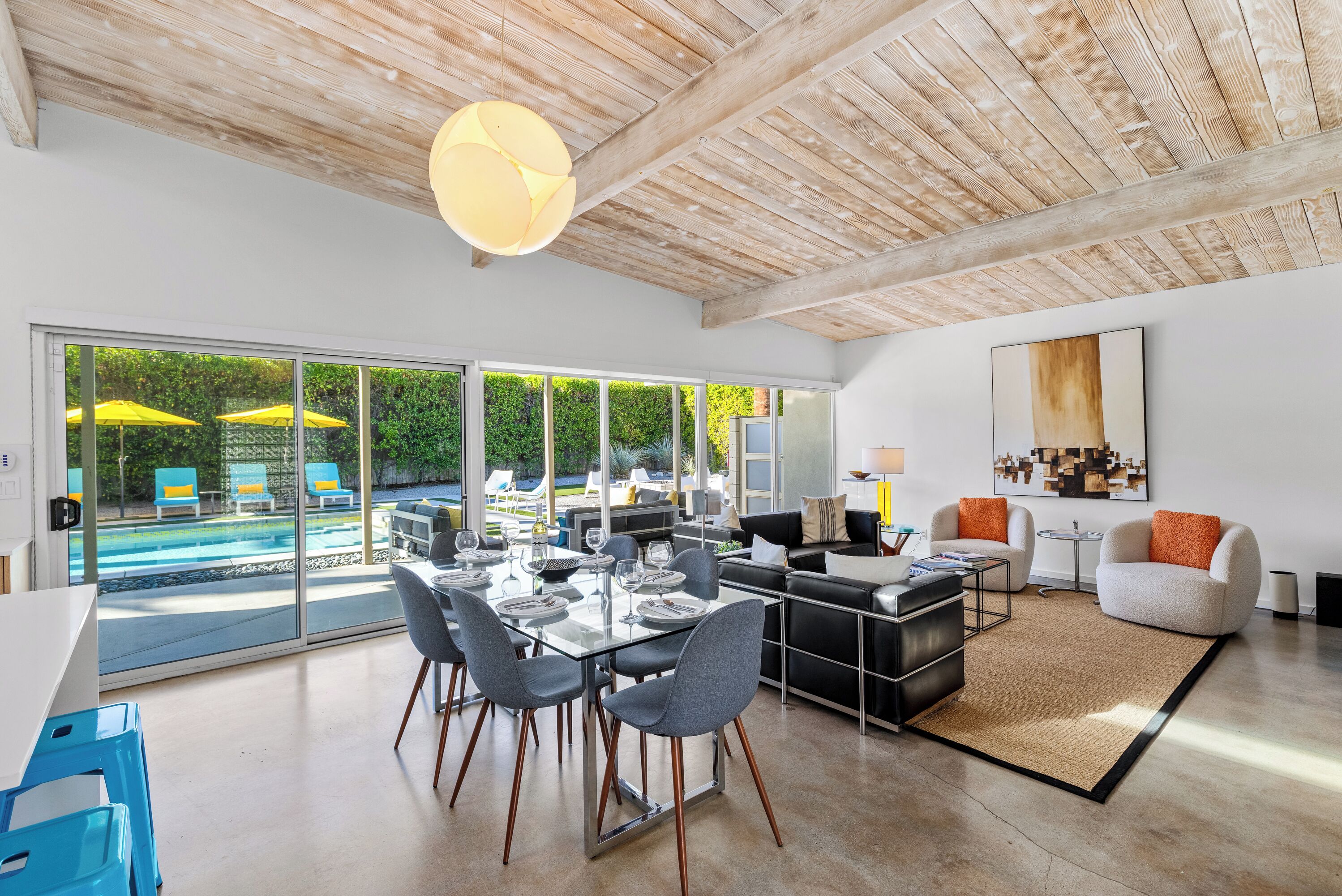 Relax in this stunning open-plan space where natural wood beams meet modern comfort, with pool views just steps away.
