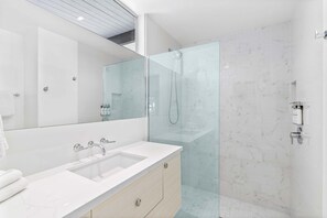 A modern bathroom with a glass-enclosed shower, a large mirror, and a white sink. - Midcentury Cool – Palm Springs Modern Home (Palm Springs)