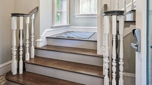 A staircase with white balusters and dark wooden steps leading to a landing. - Beautiful Luxury Southern Style Home located in Anna Maria - Walk easily to Beach, Sleeps 6! (Anna Maria)