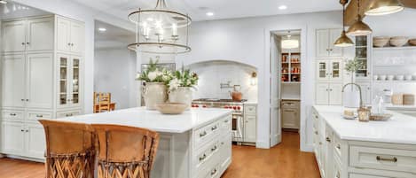 Step into this stunning chef's kitchen where elegant white cabinetry meets warm brass fixtures, creating your perfect culinary haven for memorable meals - Main House