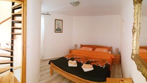 A bedroom with a wooden bed, a small bedside table, a nightstand, a mirror, and a spiral staircase leading to an upper level. - Vacation house with PRIVATE garden, pool, table tennis and soccer. Max 4 persons (Svetvincenat)