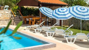 A swimming pool with lounge chairs and umbrellas, a covered patio area, and a stone wall. - Vacation house with PRIVATE garden, pool, table tennis and soccer. Max 4 persons (Svetvincenat)