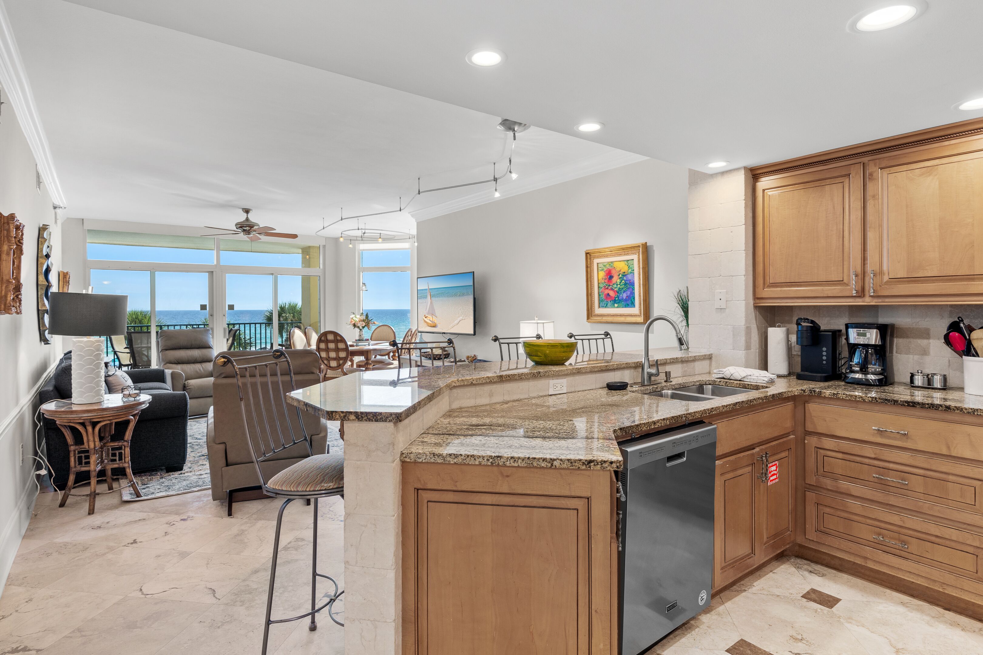 A modern kitchen with granite countertops, wooden cabinets, and a built-in dishwasher.
